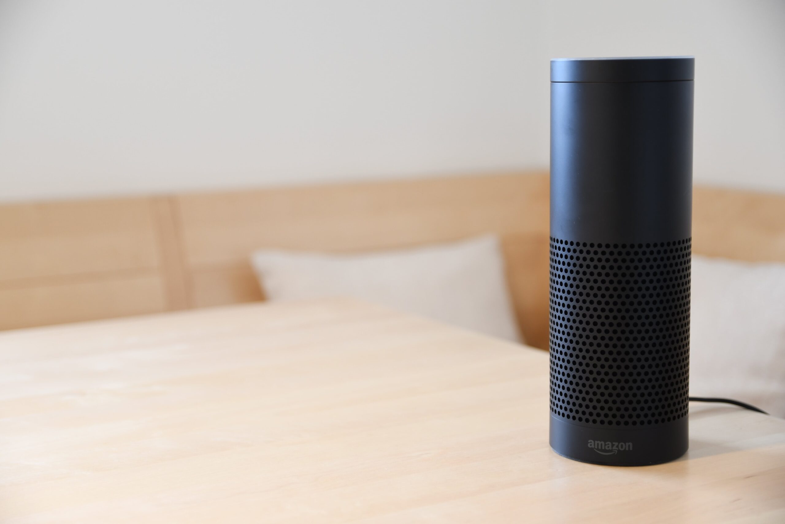 an amazon echo device on a wood surface.